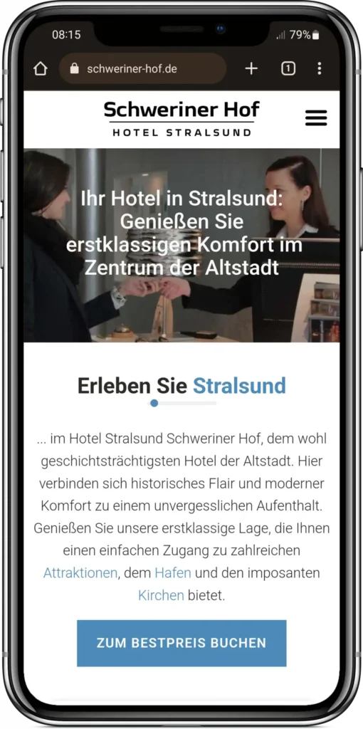 Smartphone zeigt responsive Website vom Hotel Schweriner Hof Stralsund mit Hero-Bild der Hotelrezeption und Willkommenstext